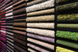 Samples of carpets of different colors on a stand in a store or production. Multi-colored carpet samples on the floor