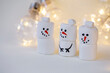 © Nady - team of marshmallow snowmen on a beige background in the lighting of a garland