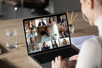 Wall Mural - smiling female employee using computer software application, holding video conference online call wi