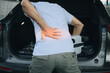 © anut21ng Stock - Men have back pain while carrying luggage in car
