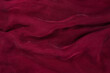 Soft smooth burgundy silk fabric background. Fabric texture.