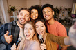 © Kostiantyn - Capture the moment. Cheerful young multicultural friends taking a selfie using smartphone while spending time together, playing karaoke at home