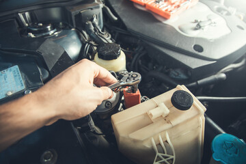 Car mechanic using socket wrench