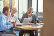 © Kostiantyn - Three mature colleagues sitting in the modern office and discussing business strategy, business people working together