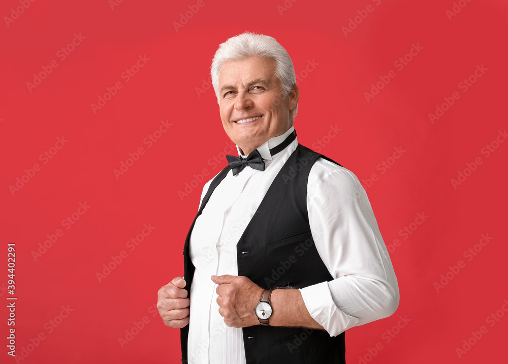 Stylish senior man on color background