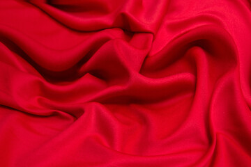 Red silk fabric cloth waves background texture.