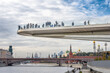 The floating bridge with people above Moscow river in the park Zaryadye near Red Square. Landscape Floating pedestrian Bridge Zaryadye park, in front of the Moscow Kremlin, Russia
