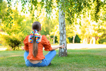 Sticker - Beautiful young woman meditating in park