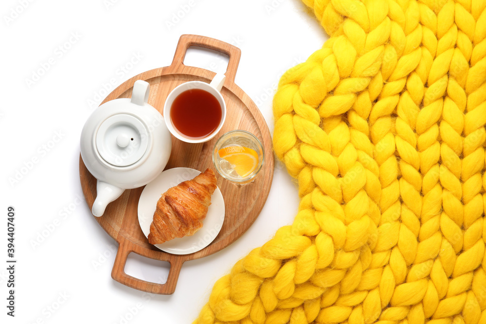 Tray with tasty breakfast and knitted plaid on white background