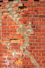 Fragment Of A Brick Textured Wall With Chips On The Corner Of The House
