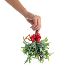 Female hand with mistletoe branch on white background