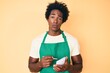 © Krakenimages.com - Handsome african american man with afro hair wearing waiter apron taking order skeptic and nervous, frowning upset because of problem. negative person.