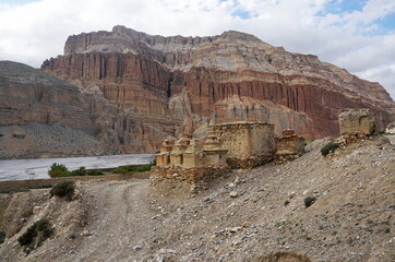 Buddhist chortens and ruins against the background of mountains, on the way to Chusang.  Upper Mustang. Nepal.