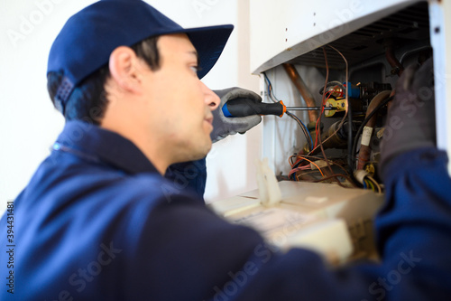 Smiling technician repairing an hot-water heater