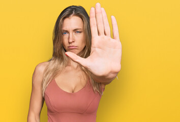 Sticker - Beautiful caucasian woman wearing casual clothes doing stop sing with palm of the hand. warning expression with negative and serious gesture on the face.