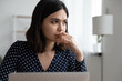 Close up thoughtful Asian young woman using laptop, looking to aside, focused businesswoman freelancer pondering project strategy, planning, pensive female student thinking about difficult task