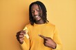 African american man with braids holding suicide prevention yellow ribbon smiling happy pointing with hand and finger