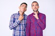 © Krakenimages.com - Young gay couple of two men wearing casual clothes thinking concentrated about doubt with finger on chin and looking up wondering