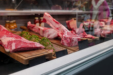 Front View Of Fresh Raw Red Good Quality Of Meat Through Glass Of Counter At The Butcher Shop.