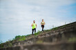 © Georgii - Athletic couple running marathon on stairs. Workout in urban outdoor. Jogging people training outside.