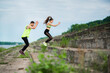© Georgii - Athletic young couple exercizing jumping on stairs outdoor, couple workout. Active lifestyle in urban
