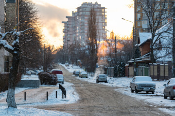 Canvas Print - Cold winter evening in the city. Cars and road covered by mud and snow.