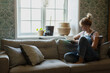 © Johnér - Woman reading on sofa, Sweden