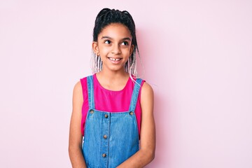 Poster - Young african american girl child with braids wearing casual clothes over pink background looking away to side with smile on face, natural expression. laughing confident.