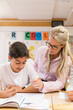 © Johnér - Teacher helping boy in classroom, Sweden