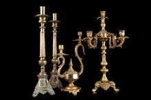 Antique Bronze Chandeliers On A Black Background, Several Types Of Old Candlesticks, Pair Of Candlesticks And Two Chandeliers On A Black Background
