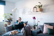 © Johnér - Woman in living room using laptop, Sweden