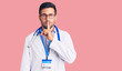 © Krakenimages.com - Young hispanic man wearing doctor uniform and stethoscope asking to be quiet with finger on lips. silence and secret concept.