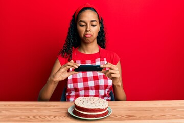 Wall Mural - Young african american girl wearing baker apron making carrot cake picture depressed and worry for distress, crying angry and afraid. sad expression.