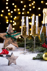 Two glasses of sparkling champagne at New year eve night with clock and bokeh background. Christmas decoration dinner table setting, copy space