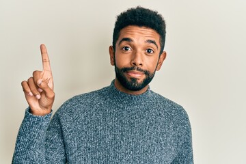 Wall Mural - Handsome young hispanic man wearing casual winter sweater peeking in shock covering face and eyes with hand, looking through fingers afraid