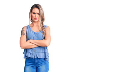 Wall Mural - Young beautiful blonde woman wearing casual sleeveless t-shirt skeptic and nervous, disapproving expression on face with crossed arms. negative person.