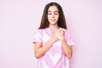 Cute hispanic child girl wearing casual clothes smiling with hands on chest with closed eyes and grateful gesture on face. health concept.