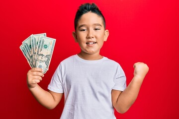 Poster - Little boy hispanic kid holding 20 dollars banknotes screaming proud, celebrating victory and success very excited with raised arm