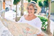 © Krakenimages.com - Middle age tourist woman with grey hair looking at city map on a summer trip on holidays