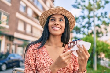 Young african american tourist woman on vacation eating cake at the city.