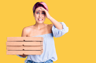 Canvas Print - Young beautiful woman with pink hair holding delivery pizza box stressed and frustrated with hand on head, surprised and angry face