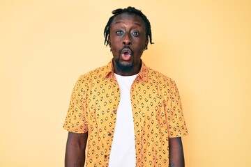 Poster - Young african american man with braids wearing casual clothes afraid and shocked with surprise expression, fear and excited face.