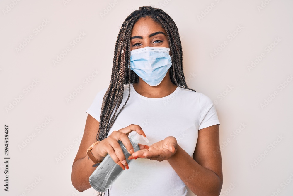 Young african american woman with braids wearing medical mask using ...