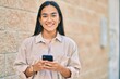 © Krakenimages.com - Young latin girl smiling happy using smartphone at the city.