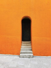 Architectural Minimalism, Orange Wall, Stairs And Dark Door.