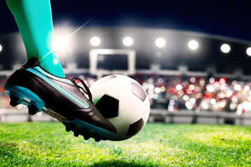 Soccer player feet kicking a ball toward a goal