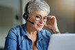 © goodluz - Mature woman with grey short hair working from home during pandemia