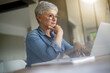 © goodluz - Portrait of a beautiful mature 50-year-old woman with white hair working from home