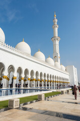 Wall Mural - Minaret and domes of white Grand Mosque against white cloudy sky, also called Sheikh Zayed Grand Mosque, inspired by Persian, Mughal and Moorish mosque architecture