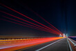 light traces of cars driving along the road at night through a beautiful modern highway bridge